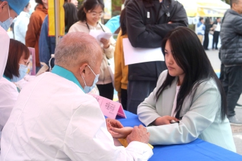 义诊服务的医务工作者正在为参与者把脉3.jpg 义诊服务的医务工作者正在为参与者把脉3.jpg