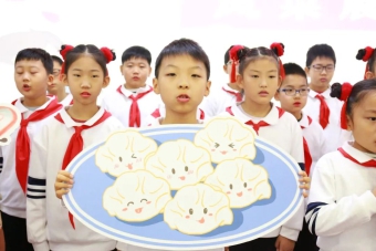 学生手持拟人化造型的饺子.jpg 学生手持拟人化造型的饺子.jpg