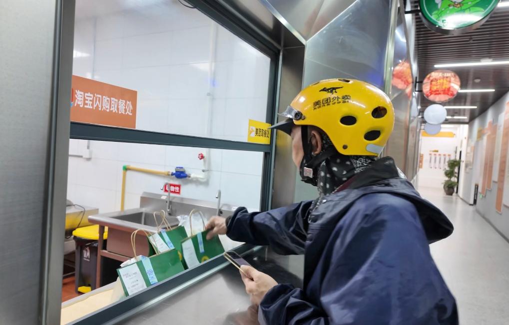 一名外卖骑手正在餐饮档口取餐.jpeg